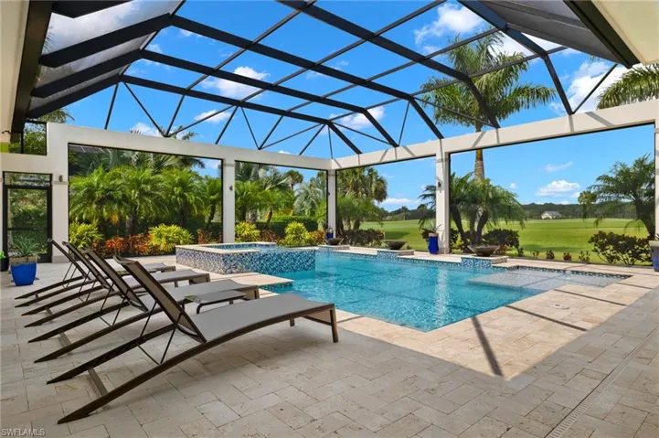 View of pool featuring a patio, an in ground hot tub, and enclosure