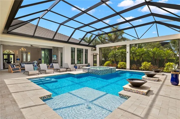 View of swimming pool with sun shelf, in ground hot tub, a patio, and a lanai