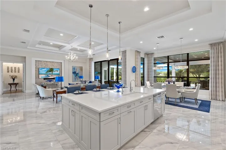 Kitchen featuring white cabinets, a kitchen island with sink, light countertops, dishwasher, and sink