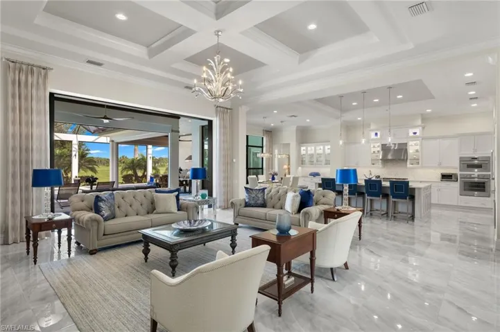 Living room featuring beam ceiling, crown molding, and 10-foot pocket doors