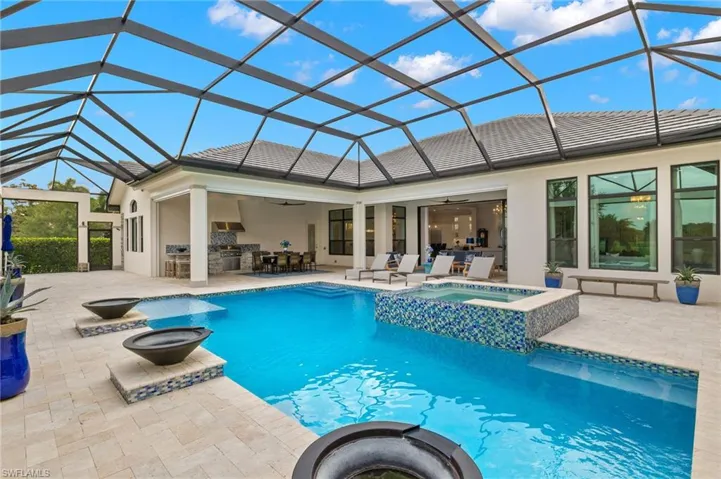 View of pool featuring a patio area, a lanai, and an in ground hot tub