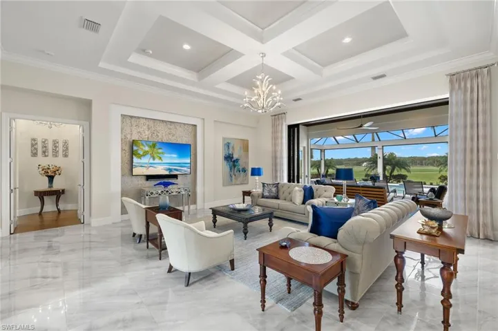 Living room with crown molding, beamed ceiling, and Chandelier