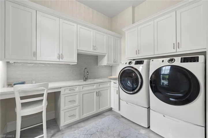 Separate laundry room with sink and cabinets