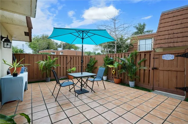 Fenced backyard featuring a patio, outdoor dining space, and a gate