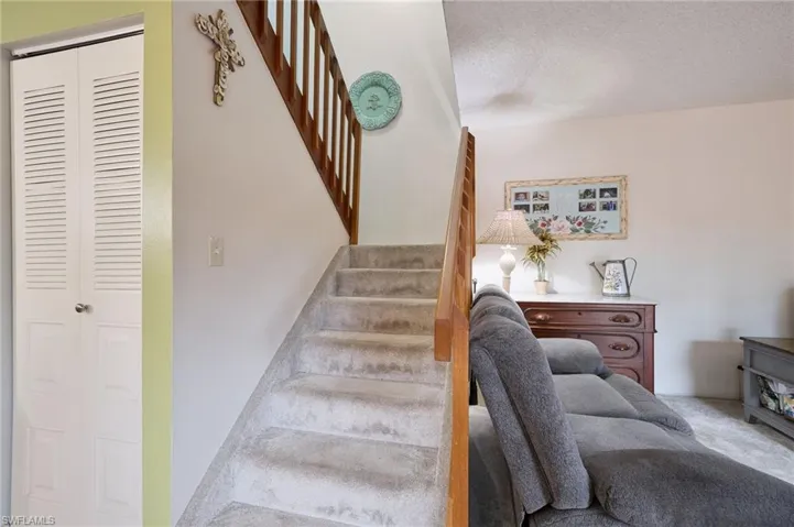 Stairs with a textured ceiling and carpet flooring