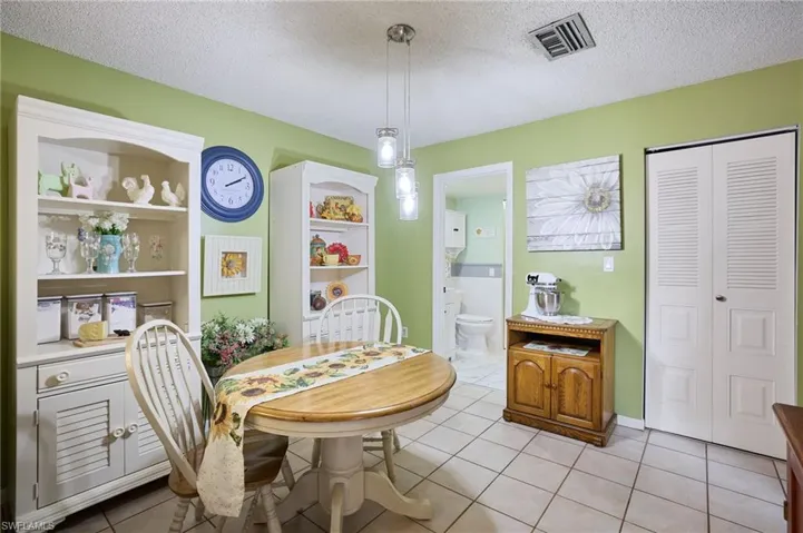 Dining area with a textured ceiling and light tile patterned flooring