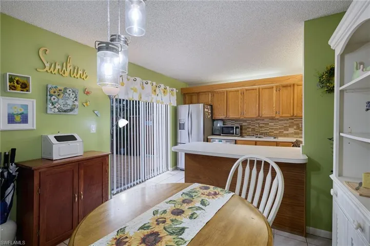 Kitchen featuring decorative backsplash, light tile patterned floors, a textured ceiling, light countertops, and appliances with stainless steel finishes