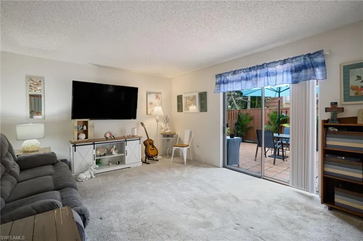 Living room with a textured ceiling and carpet flooring