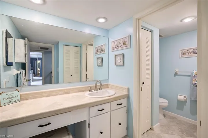Bathroom featuring a closet, vanity, and light tile patterned floors