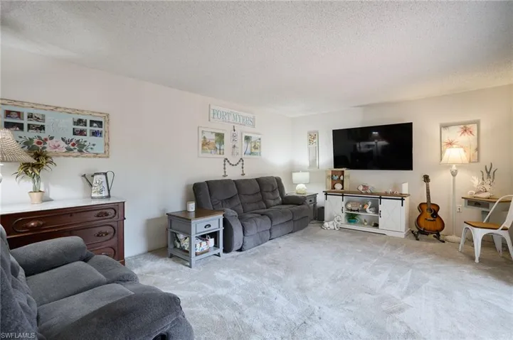 Carpeted living room featuring a textured ceiling