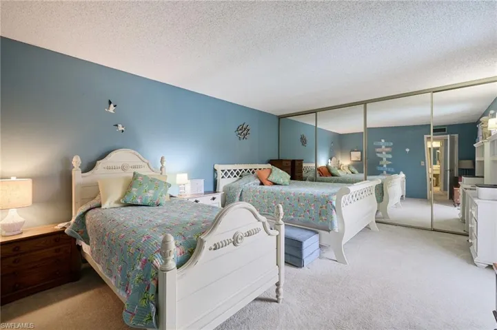 Bedroom with a closet, carpet, and a textured ceiling