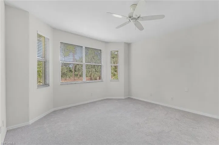 Empty room featuring ceiling fan and light colored carpet