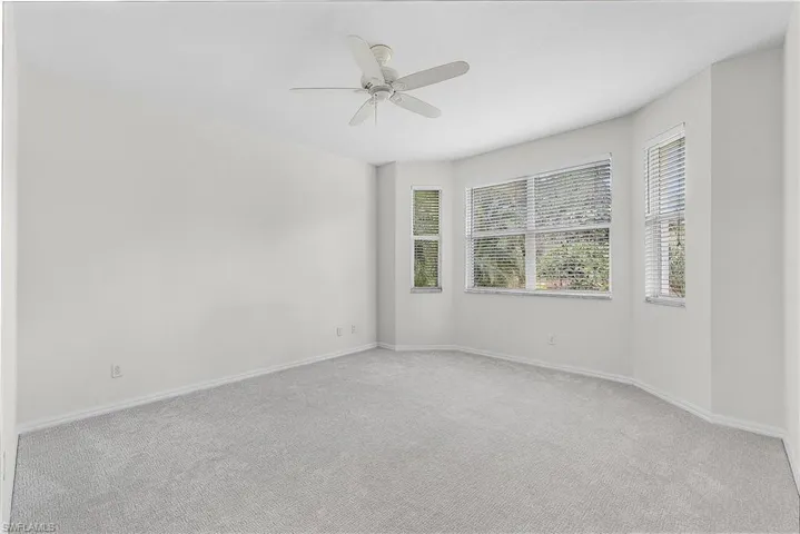 Master bedroom nfurnished room with light colored new carpet and ceiling fan