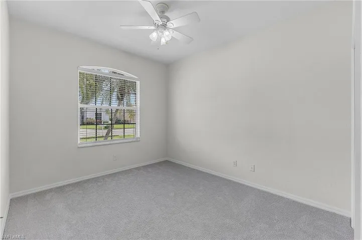 Spare room featuring ceiling fan and carpet
