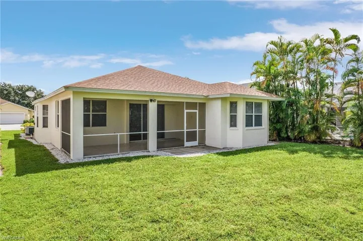 Back of property with a yard and a sunroom