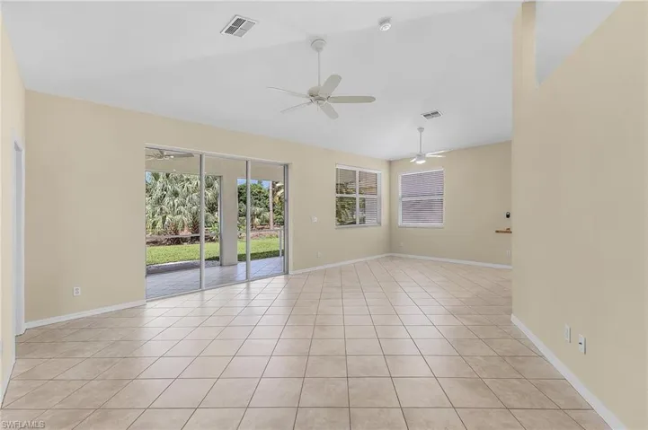 Unfurnished room featuring vaulted ceiling, light tile patterned floors, and ceiling fan