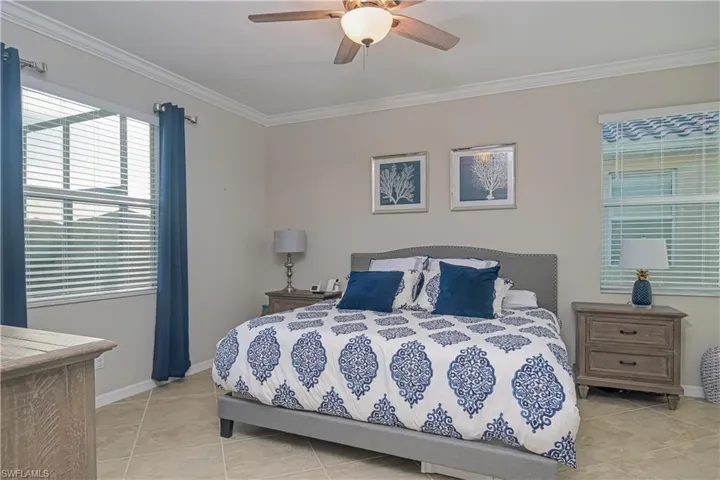 Bedroom featuring ornamental molding, ceiling fan, and light tile flooring