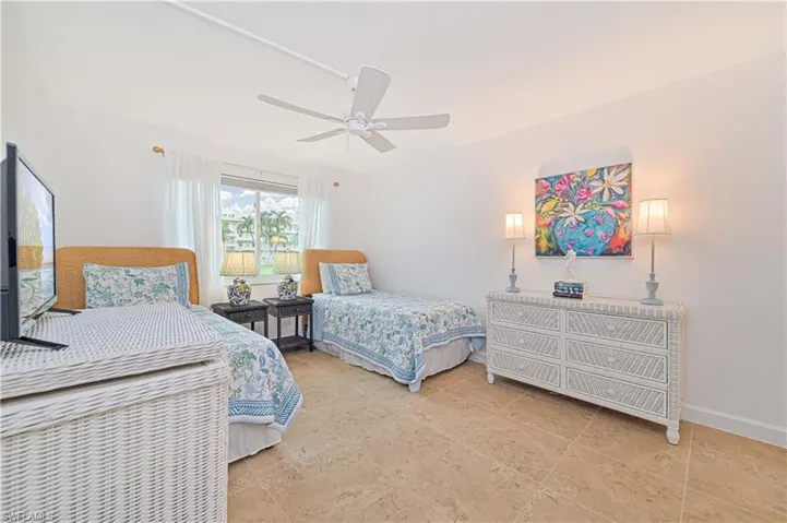 Tiled bedroom featuring ceiling fan