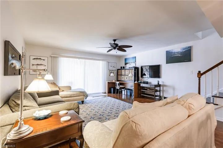 Living room featuring dark hardwood / wood-style floors and ceiling fan