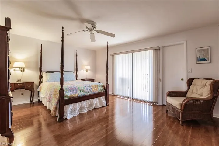 Bedroom with access to outside, ceiling fan, and dark wood-type flooring