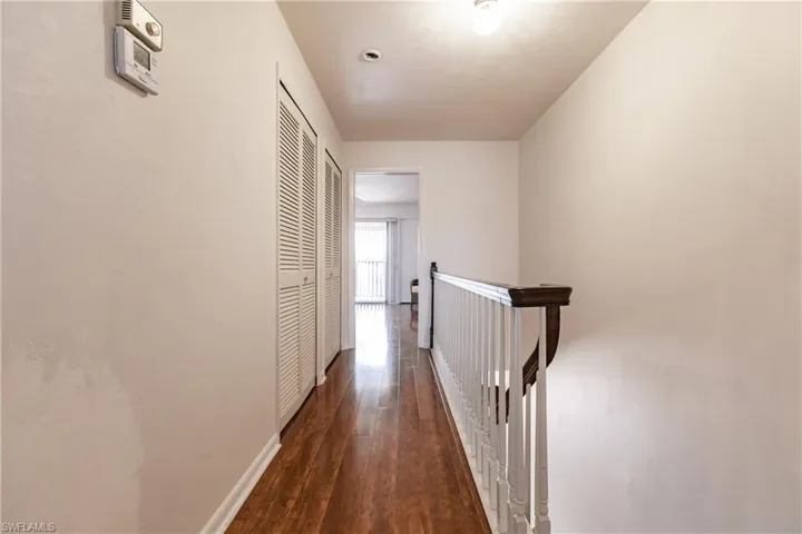 Hallway with dark hardwood / wood-style flooring