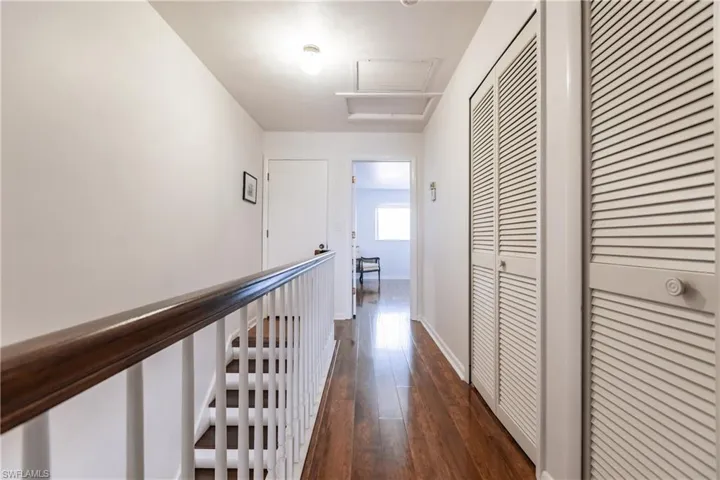 Hallway with dark hardwood / wood-style flooring