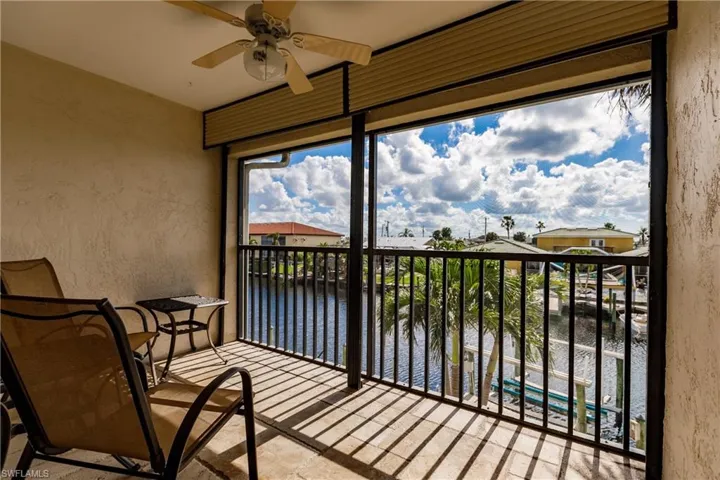 Sunroom / solarium featuring ceiling fan, a water view, and a wealth of natural light