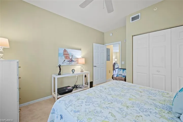 Bedroom featuring neutral wall paint, carpeted flooring, a ceiling fan, and a bi-fold closet