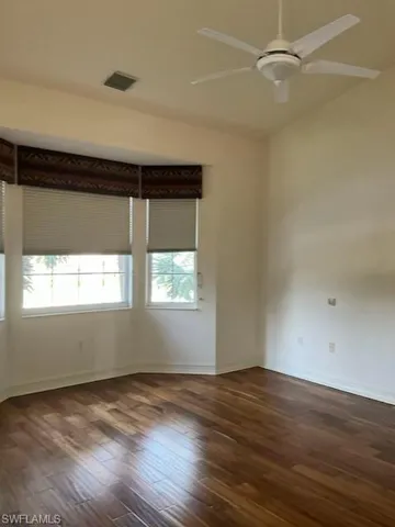 featuring ceiling fan, dark wood floors, vaulted ceiling and bay window overlooking lake