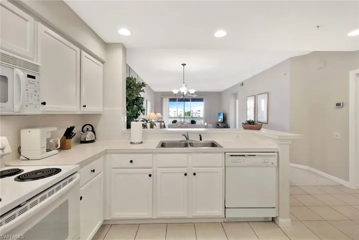 Kitchen featuring white appliances, open floor plan, white cabinetry, pendant lighting, and recessed lighting