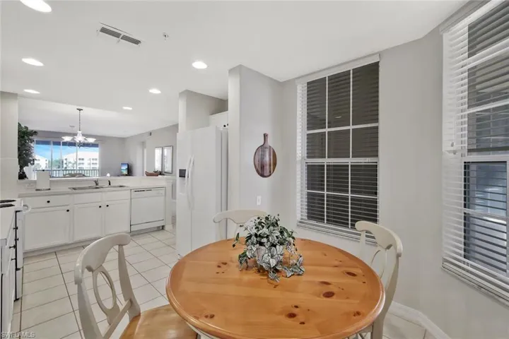 Dining space with light tile patterned flooring, a chandelier, and recessed lighting