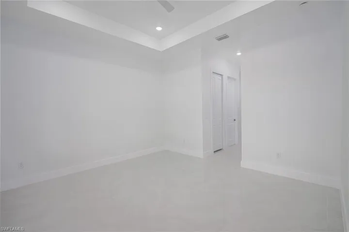 Unfurnished room featuring a tray ceiling, recessed lighting, and ceiling fan