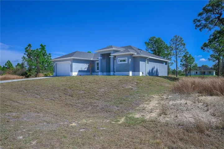 Prairie-style home featuring an attached garage, stucco siding, and a front lawn