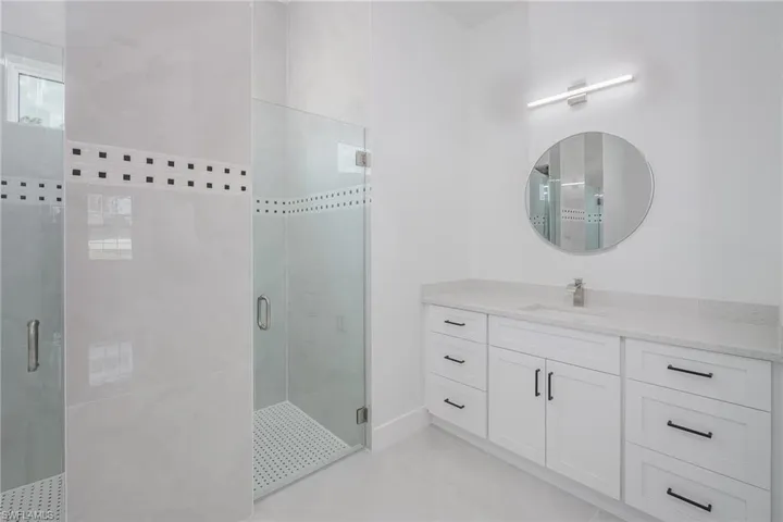 Full bathroom with vanity and a stall shower