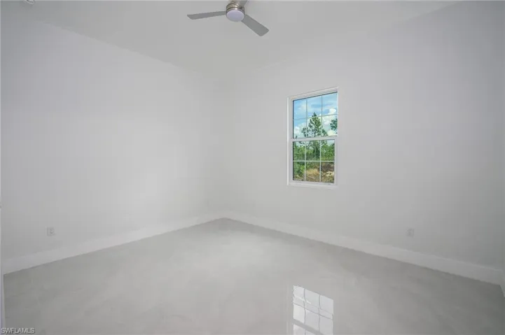 Spare room with baseboards and a ceiling fan
