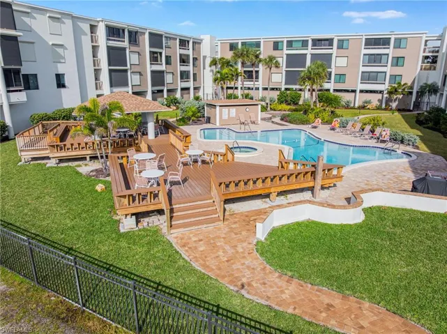 Community pool featuring a wooden deck and a patio area