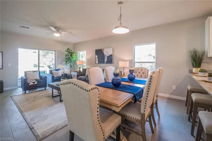Dining space featuring plenty of natural light, a ceiling fan, and dark tile patterned floors