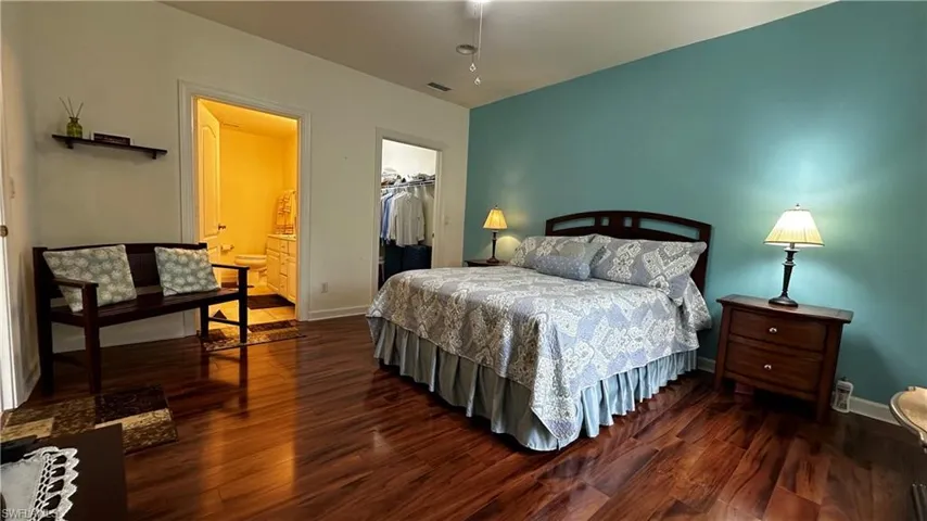 Bedroom featuring dark hardwood / wood-style floors, a closet, and a spacious closet