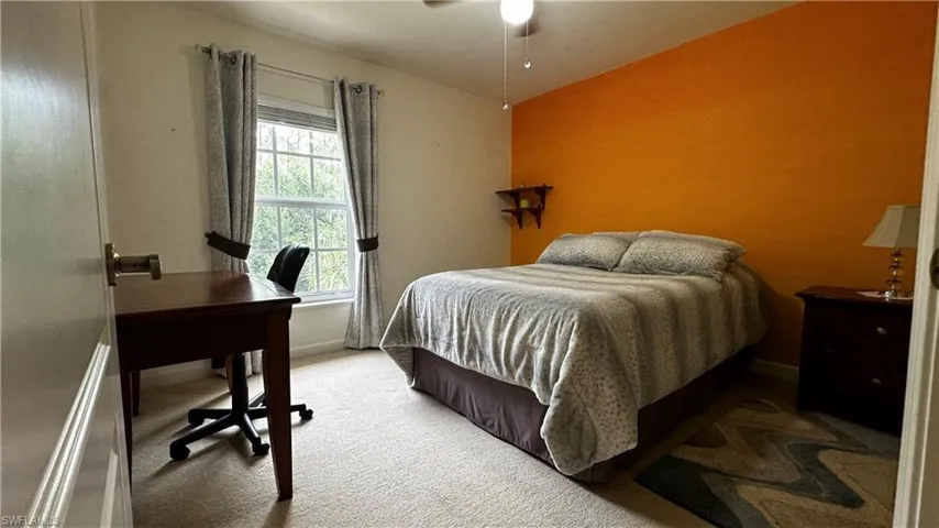 Carpeted bedroom featuring ceiling fan