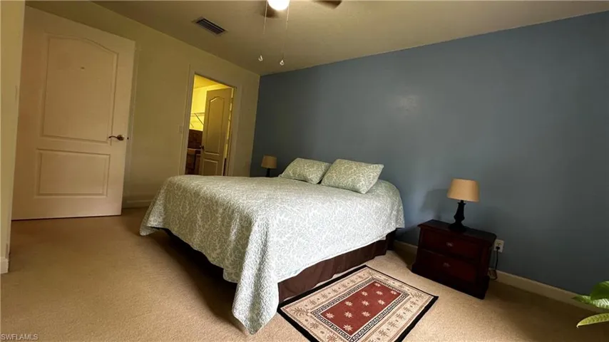 Carpeted bedroom featuring ceiling fan