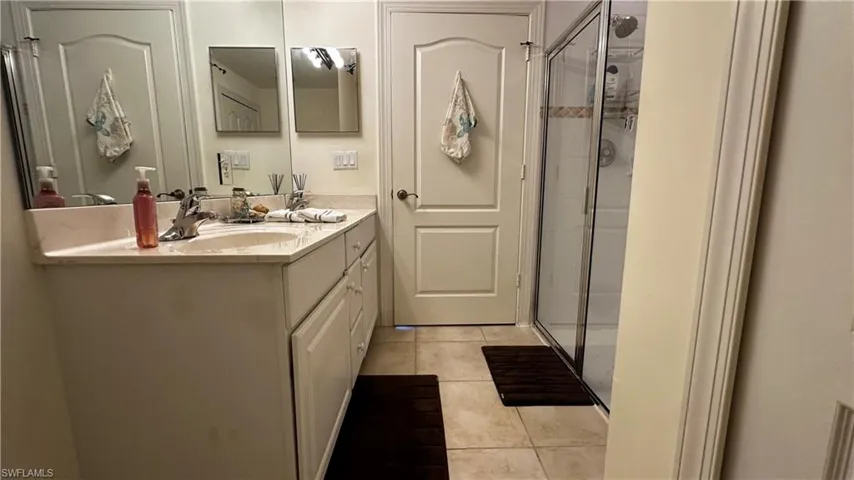 Bathroom featuring vanity, tile patterned floors, and an enclosed shower