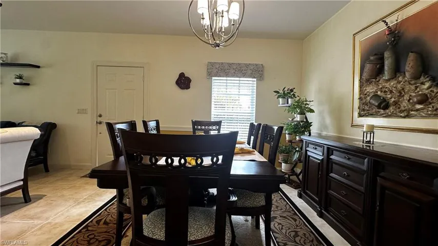 Dining space featuring a notable chandelier and light tile patterned floors