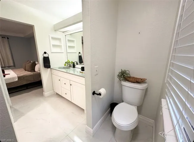 Bathroom with tile flooring, toilet, and large vanity