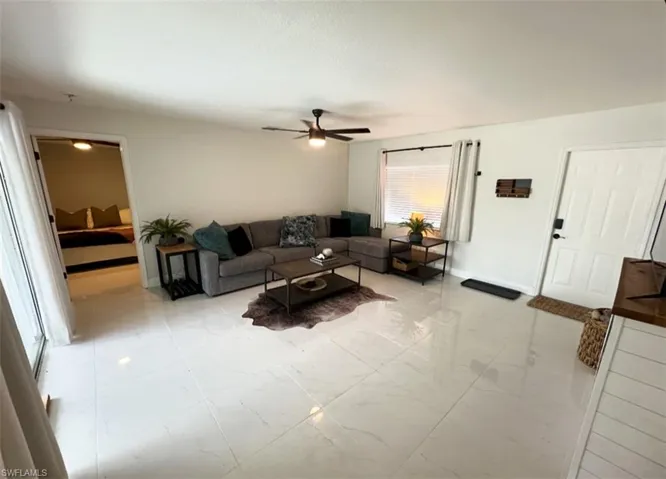 Living room featuring ceiling fan and light tile floors