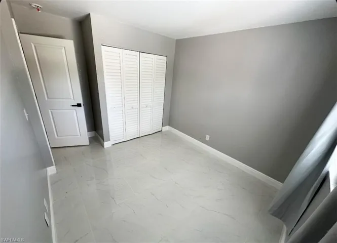 Unfurnished bedroom with tile flooring and a closet