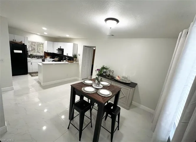 Dining room with a wealth of natural light, light tile flooring, and a textured ceiling