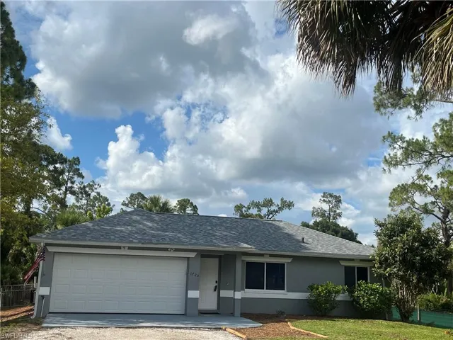 Single story home featuring a garage and a front yard