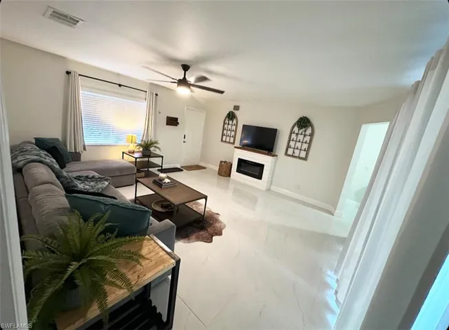 Tiled living room featuring ceiling fan