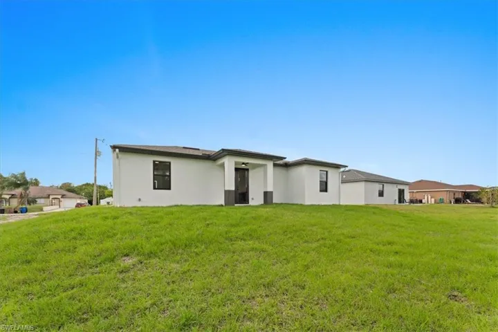 Back of house with a yard