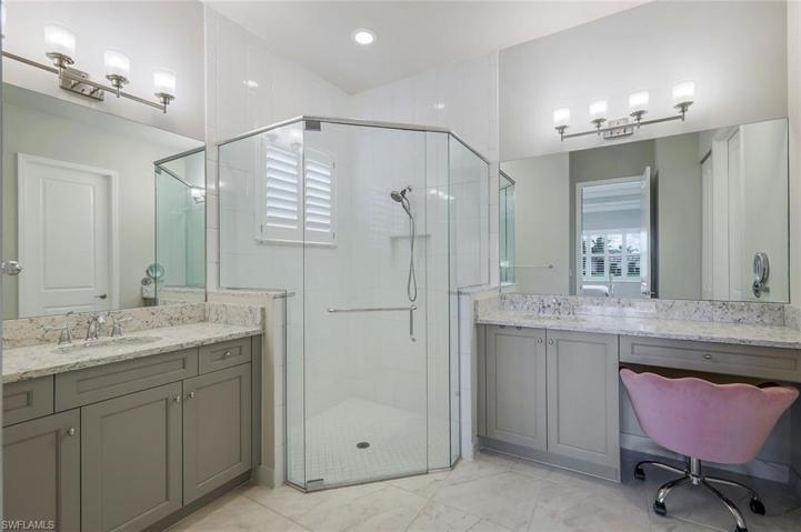 Primary bathroom offers dual sinks, vanity, private toilet room, and a large walk-in shower.